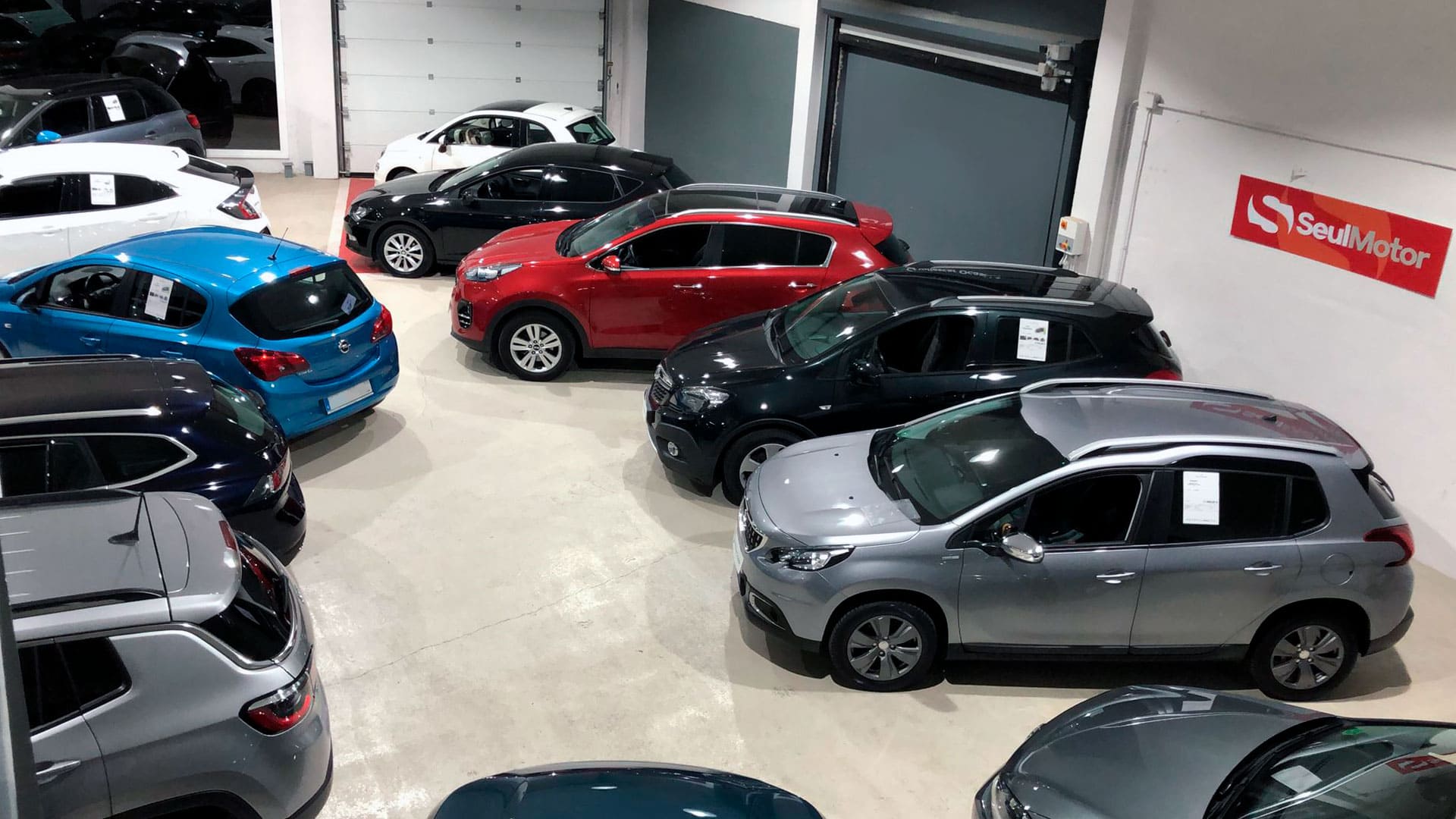 Comparativa entre coches km 0, seminuevos y de segunda mano expuestos en un concesionario de vehículos de ocasión.